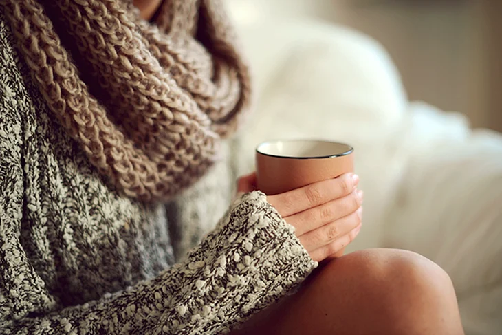 Девушка в свитере с кофе